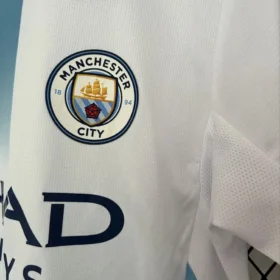 Terza Maglia Manchester City 2026/27 — fotografia reale dello stemma e del tessuto