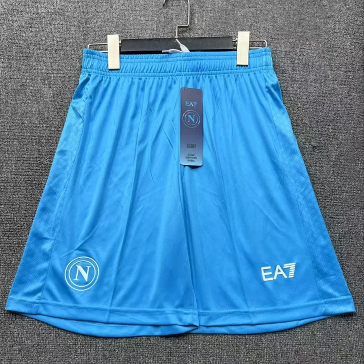 Pantaloncini Napoli 2025/26 azzurri con scudetto SSC Napoli e logo EA7