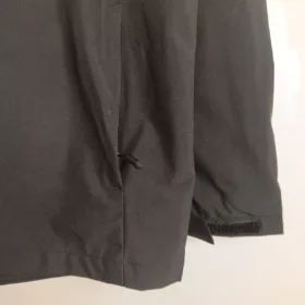 Chaqueta cortavientos Milan negra con capucha – detalle real de bolsillo y puño