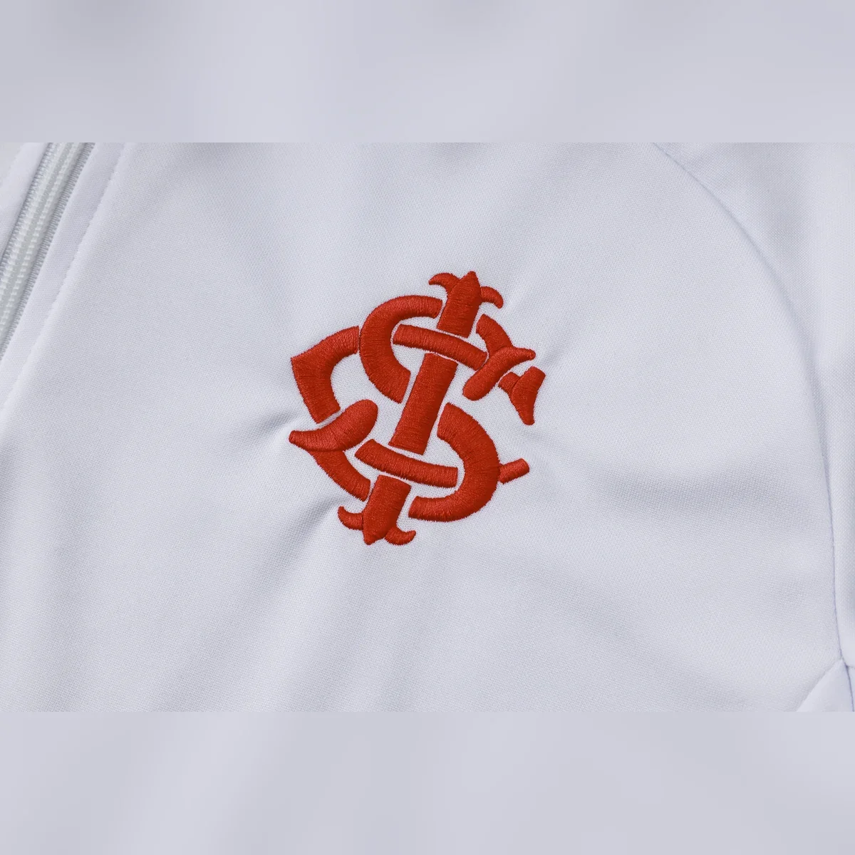 Chándal Internacional Blanco y Negro con Detalles Rojos – detalle del escudo