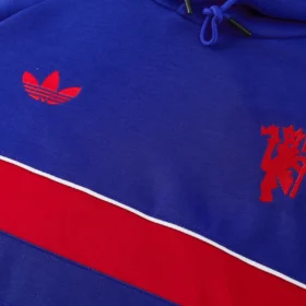 Tuta Manchester United 2026/27 Blu e Rossa con Cappuccio – fotografia del dettaglio 1