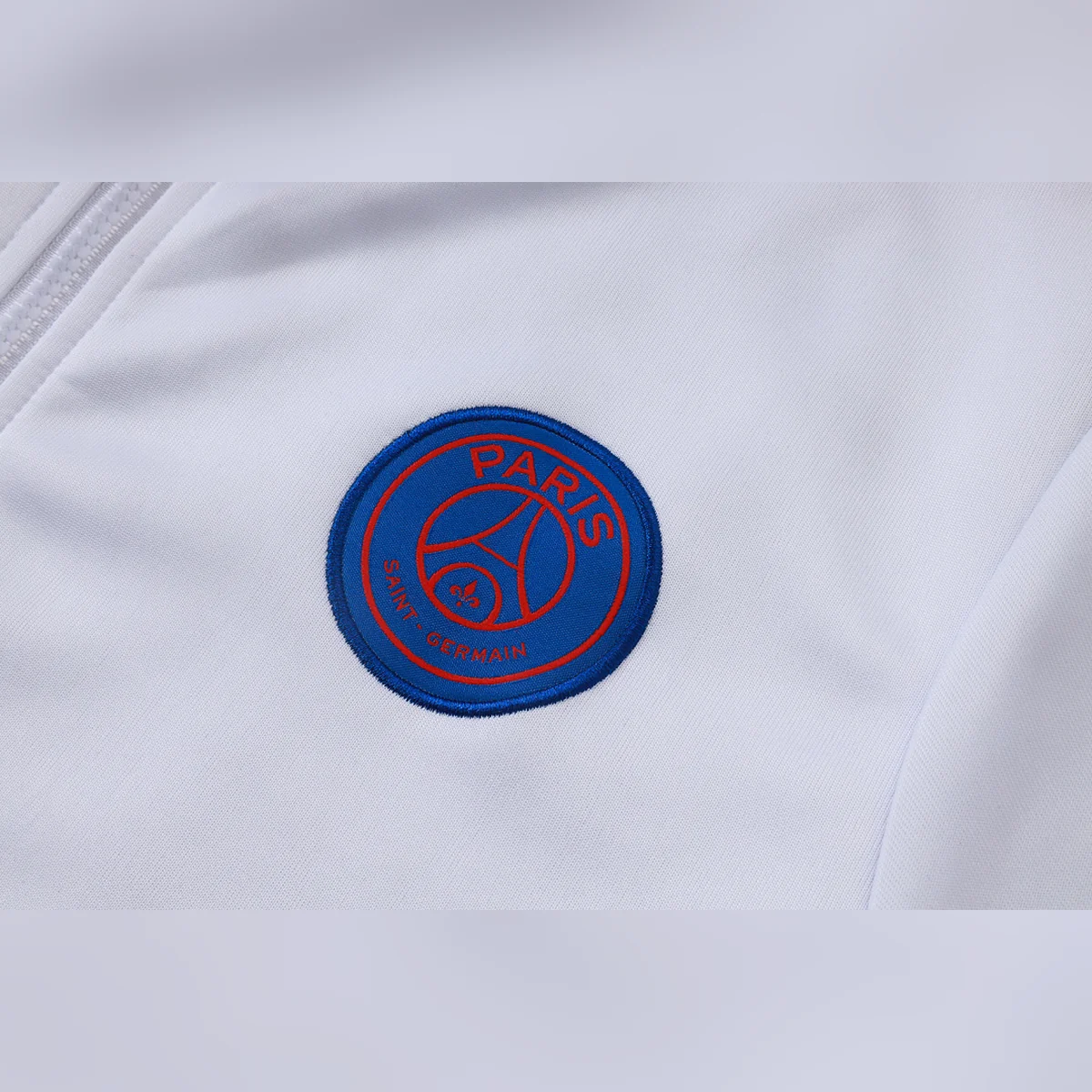 Tuta PSG Bianca Full Zip con Bande Rosse 2026/27 – dettaglio stemma