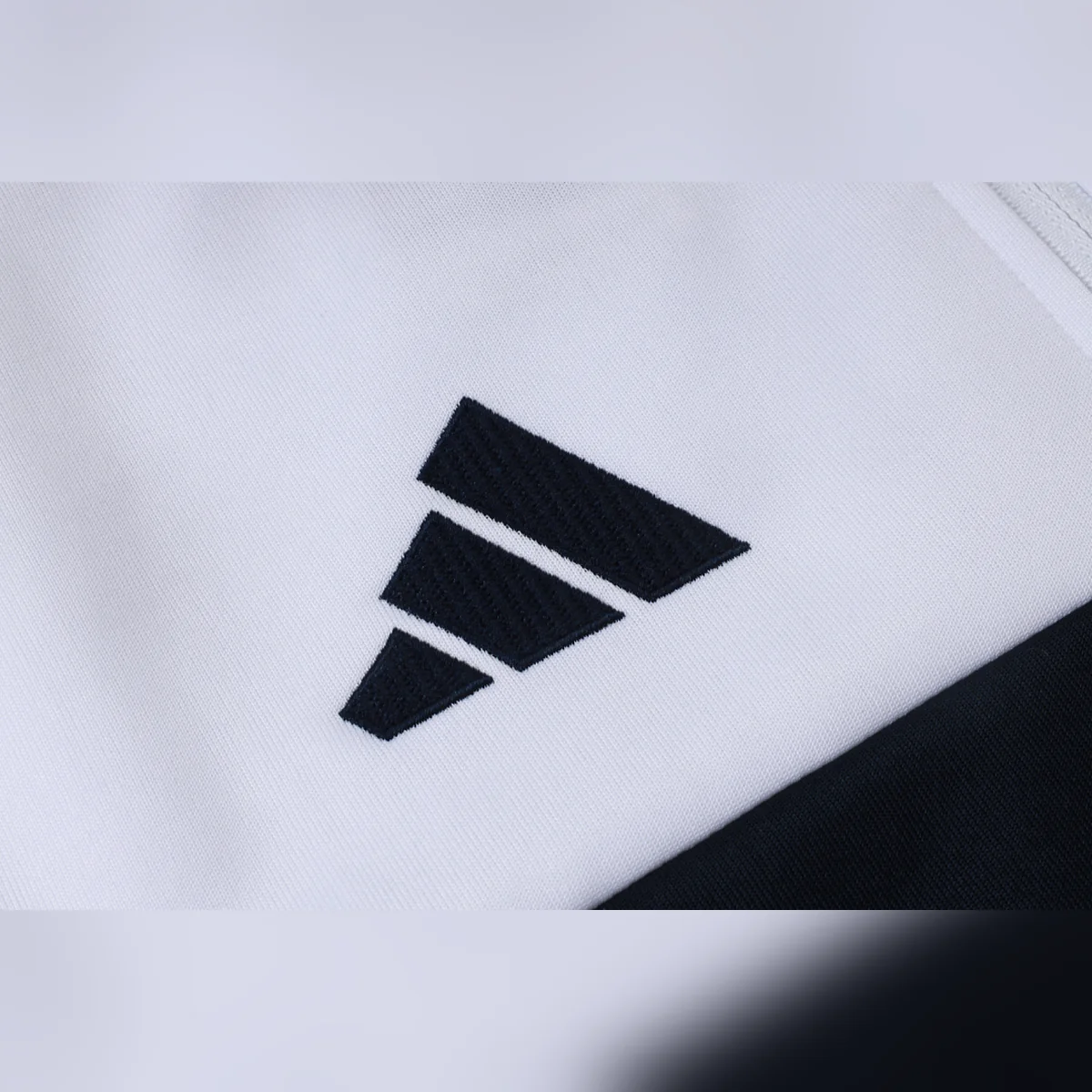 Chándal Real Madrid Blanco Franja Azul Marino 2026/27 – detalle del logotipo adidas