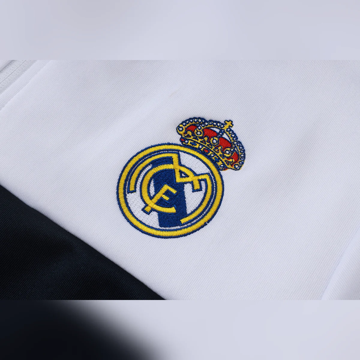 Chándal Real Madrid Blanco Franja Azul Marino 2026/27 – detalle del escudo