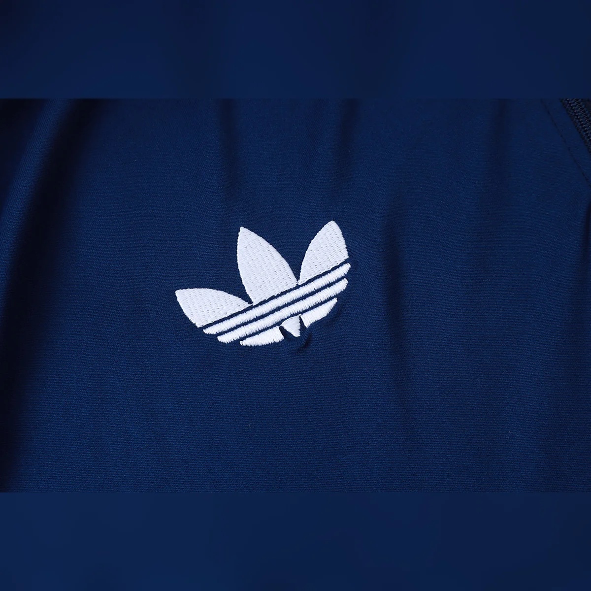 Chándal Real Madrid Azul Media Cremallera Dorado 2026/27 – detalle del trébol de adidas
