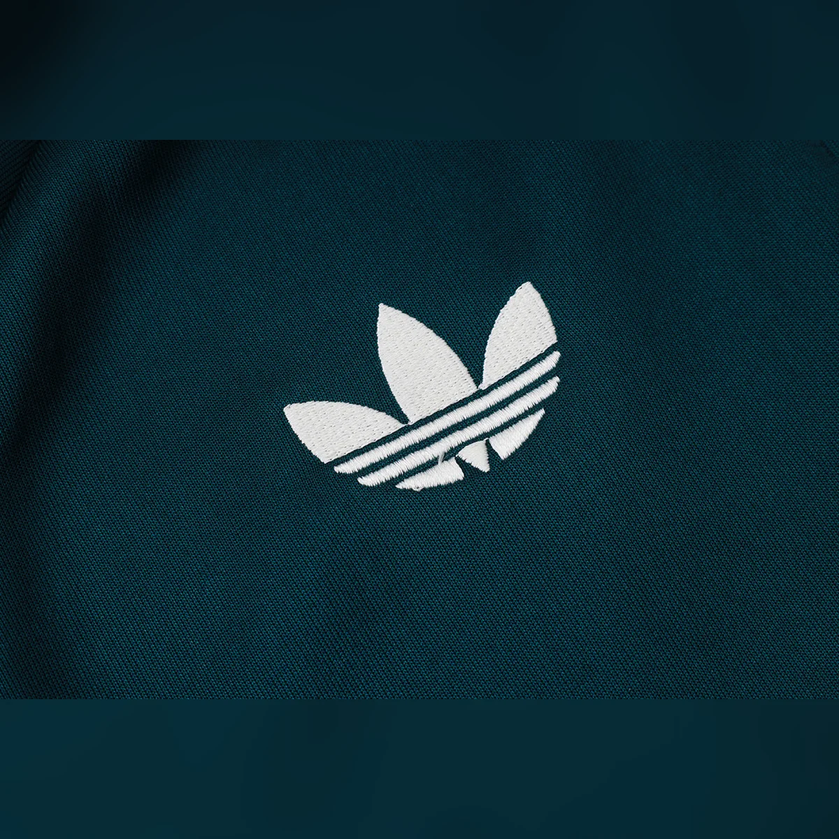 Chándal Real Madrid Verde Oscuro Franja Blanca 2026/27 – detalle del trébol de adidas